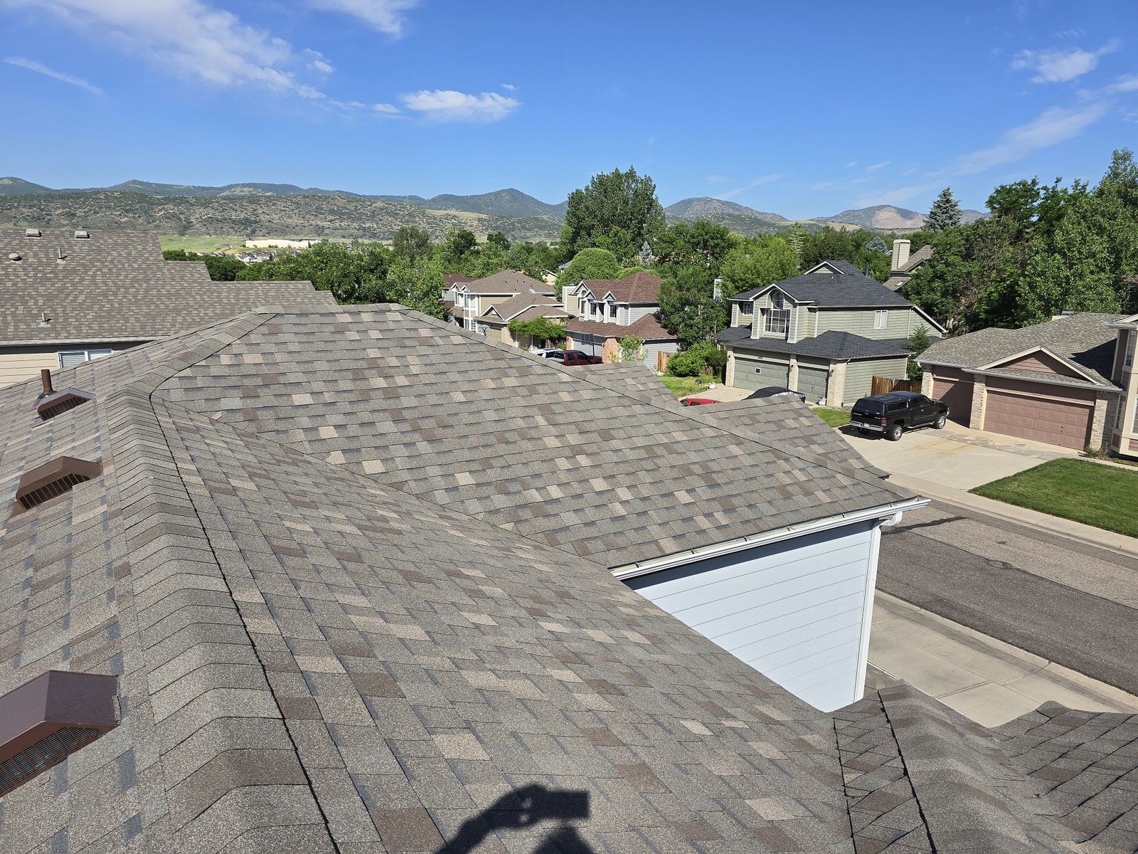 Roofing contractors repairing shingles on a Denver, CO home